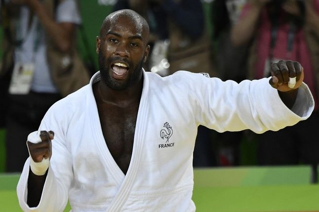 France's Teddy Riner (white) celebrates after defeating Japan's Hisayoshi Harasawa during the men's judo +100kg final gold medal contest at the Rio 2016 Olympic Games in Rio de Janeiro on August 12, 2016 / AFP PHOTO / Jeff PACHOUD