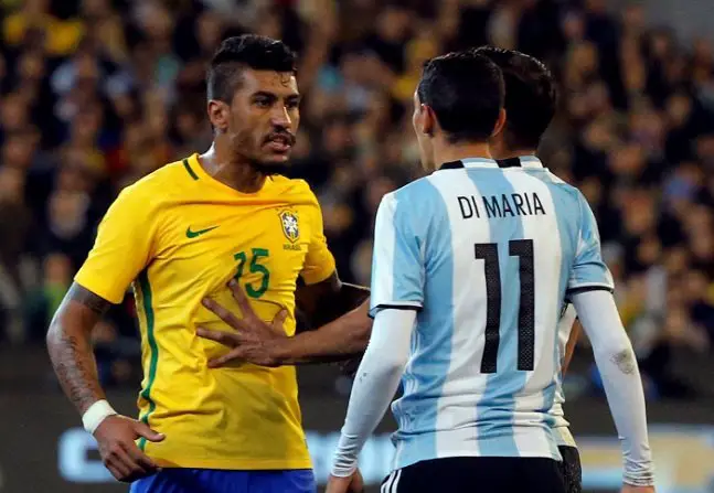Brazil's Paulinho confronts Argentina's Angel Di Maria