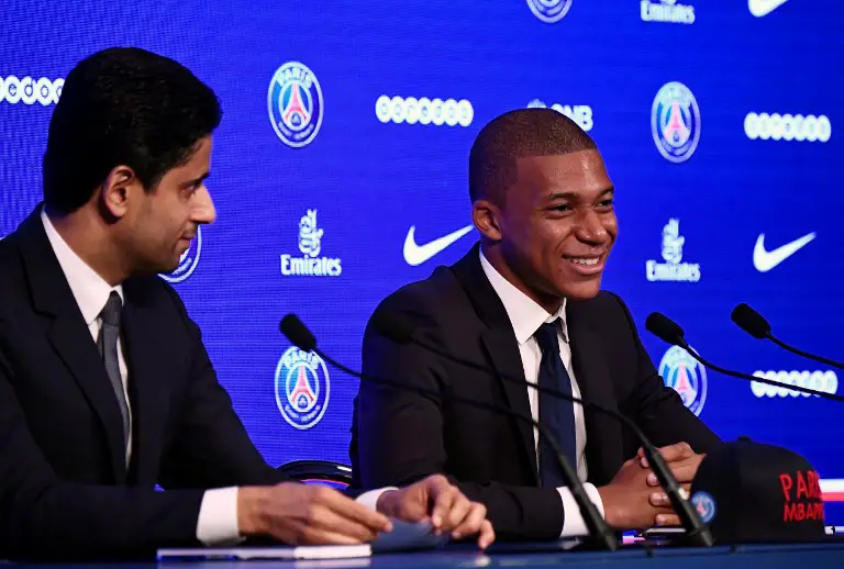 Paris Saint-Germain's new forward Kylian Mbappe (R) speaks as he sits next to Paris Saint Germain's Qatari president Nasser Al-Khelaifi during his presentation during a press conference at the Parc des Princes stadium in Paris on September 6, 2017.
The 18-year-old striker moved to PSG in a season-long loan deal with a 180 million euro buy-out clause attached, making him the second most expensive player of all time behind new teammate Neymar. / AFP PHOTO / CHRISTOPHE SIMON