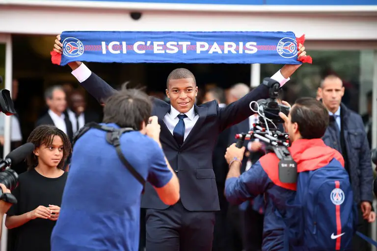 Paris Saint-Germain's new forward Kylian Mbappe stands next to his brother Ethan (L) as he holds a PSG fan scarf during his presentation at the Parc des Princes stadium in Paris on September 6, 2017.
The 18-year-old striker moved to PSG in a season-long loan deal with a 180 million euro buy-out clause attached, making him the second most expensive player of all time behind new teammate Neymar. / AFP PHOTO / FRANCK FIFE