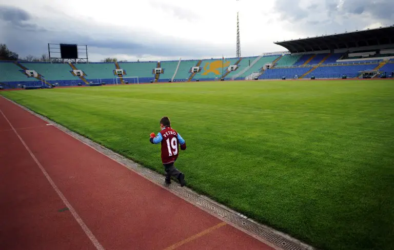 A boy runs besides the playing field at the Vassil Levski Stadium prior to a rally in support of the captain of the Bulgarian national soccer team, who is also an Aston Villa player, in Sofia, on April 19, 2012. Stiliyan Petrov, the Bulgarian soccer team captain, has been recently diagnosed with acute leukaemia. Over a thousand supporters gathered today in Sofia at a rally organized through social networks in solidarity with Petrov.        AFP PHOTO / NIKOLAY DOYCHINOV / AFP PHOTO / NIKOLAY DOYCHINOV