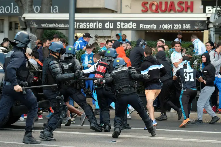 Police charge Olympique de Marseille supporters on October 22, 2017, near the Velodrome Stadium in Marseille, southeastern France, a few hours prior to kick off of the French L1 football match between Marseille (OM) and Paris Saint-Germain (PSG). / AFP PHOTO / BORIS HORVAT