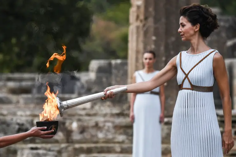 Actress Katerina Lechou (R), acting the high priestess, lights the Olympic flame at the Temple of Hera in Olympia, the sanctuary where the Olympic Games were born in 776 BC, on October 24, 2017 during the lighting ceremony of the Olympic flame for the 2018 Winter Olympics in Pyeongchang, South Korea. 
The 2018 Winter Olympics will take place from February 9 until February 25, 2017. / AFP PHOTO / ARIS MESSINIS