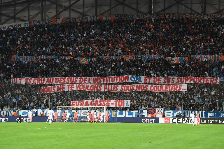 Olympique de Marseille fans hold a banner reading "You thought you were above the institution OM and its supporters. We don't want you wearing our colours. Evra get out!" prior to the start of the French L1 football match between Olympique de Marseille (OM) and Caen at the Velodrome stadium in Marseille on November 5, 2017.   / AFP PHOTO / BORIS HORVAT