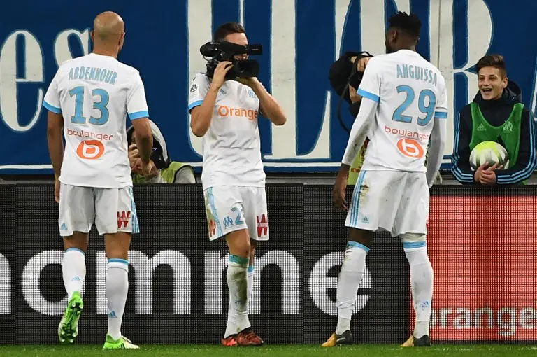 Olympique de Marseille's French midfielder Florian Thauvin (C) films his teammates with a camera as he celebrates after scoring a goal, during the French L1 football match between Olympique de Marseille (OM) and Caen at the Velodrome stadium in Marseille on November 5, 2017.  / AFP PHOTO / BORIS HORVAT