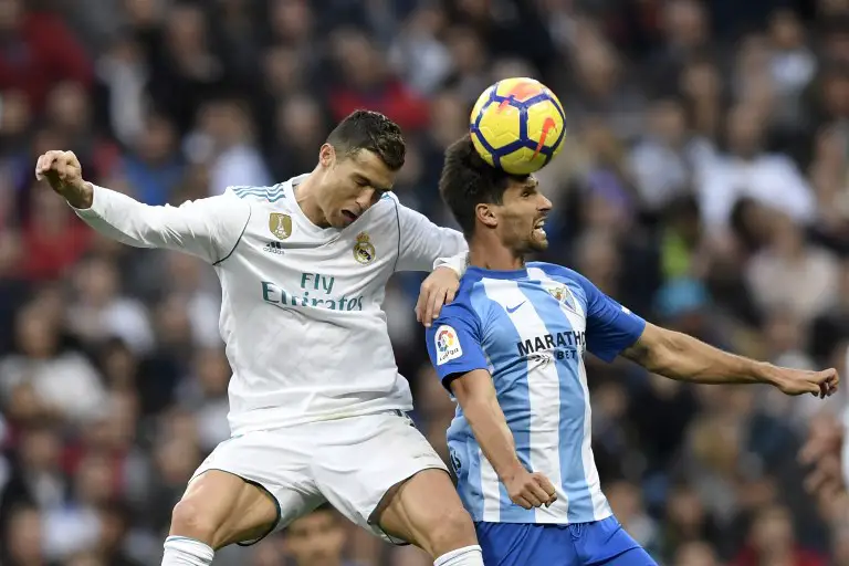 Real Madrid's Portuguese forward Cristiano Ronaldo (L) jumps for the ball with Malaga's Spanish midfielder Adrian Gonzalez Morales  during the Spanish league football match Real Madrid CF against Malaga CF on 25, November 2017 at the Santiago Bernabeu stadium in Madrid. / AFP PHOTO / GABRIEL BOUYS
