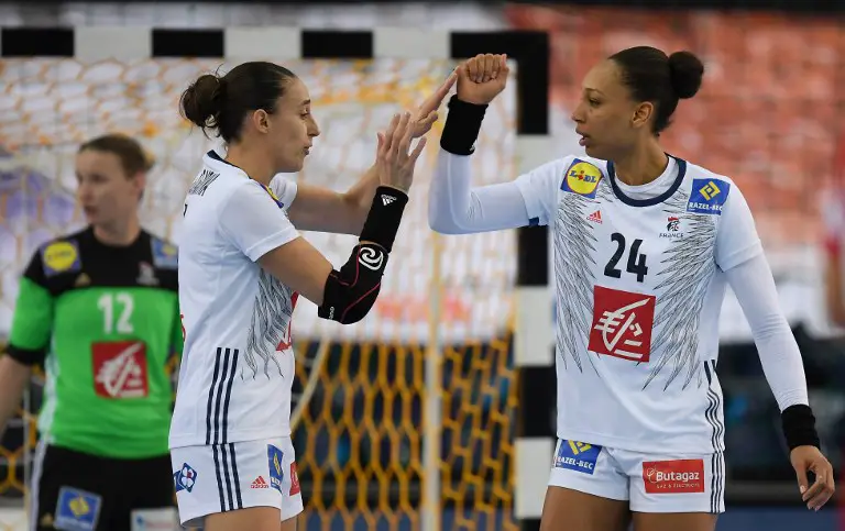 France's Camille Ayglon Saurina (l) and Beatrice Edwige celebrate during IHF Womens World Championship round of sixteen handball match Hungary vs France in Leipzig, eastern Germany, on December 10, 2017. / AFP PHOTO / ZB AND dpa / Hendrik Schmidt / Germany OUT
