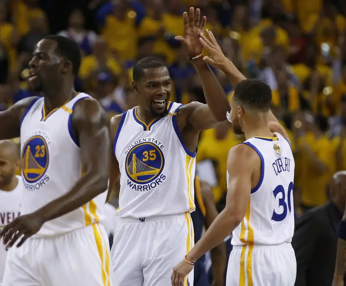 The Golden State Warriors' Kevin Durant (35) high-fives teammate Stephen Curry (30) during the second quarter against the Cleveland Cavaliers in Game 1 of the NBA Finals at Oracle Arena in Oakland, Calif., on Thursday, June 1, 2017. The Warriors won, 113-91.