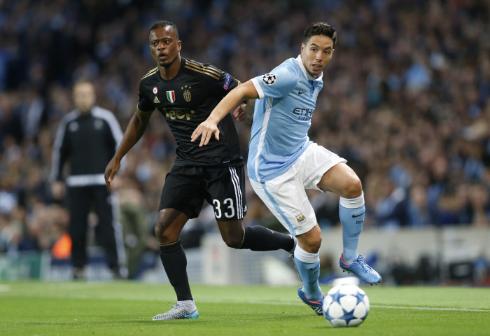 Juventus' Patrice Evra in action with Manchester City's Samir Nasri