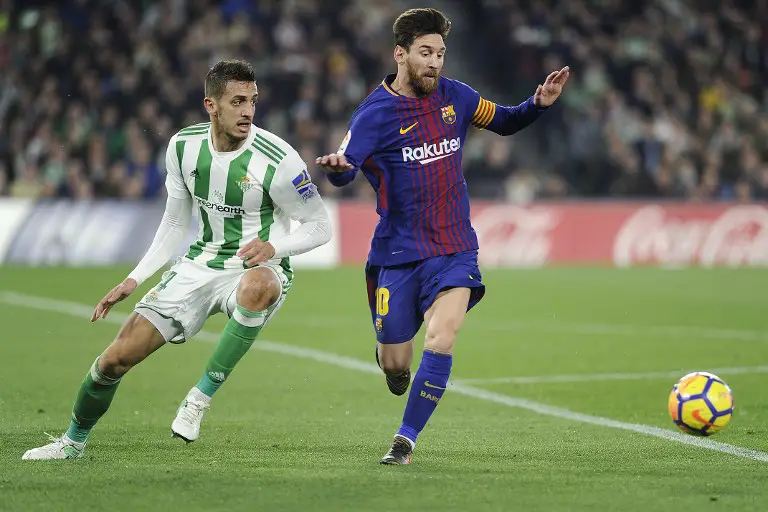 Barcelona's Argentinian forward Lionel Messi (R) challenges Real Betis' Moroccan defender Zou (L) during the Spanish league football match between Real Betis and FC Barcelona at the Benito Villamarin stadium in Sevilla on January 21, 2018. / AFP PHOTO / CRISTINA QUICLER