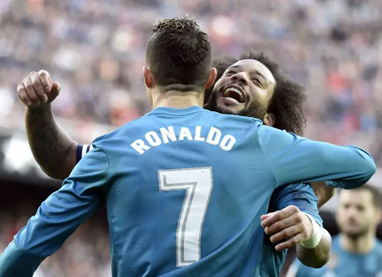 Real Madrid's Portuguese forward Cristiano Ronaldo (L) celebrates his second goal with Real Madrid's Brazilian defender Marcelo during the Spanish league football match between Valencia CF and Real Madrid CF at the Mestalla stadium in Valencia on January 27, 2018. / AFP PHOTO / JOSE JORDAN