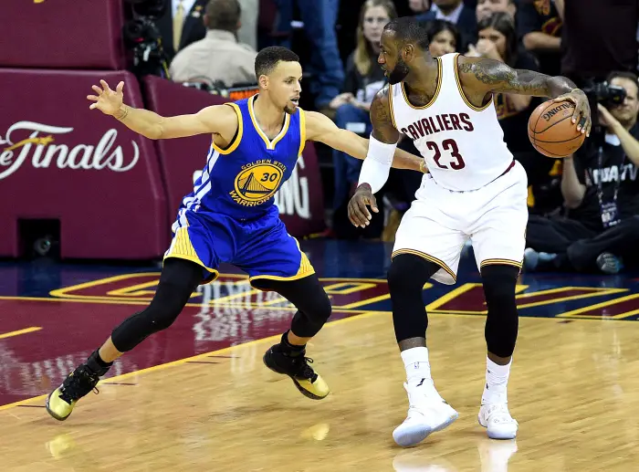 Cleveland Cavaliers forward LeBron James (23) handles the ball against Golden State Warriors guard Stephen Curry (30) during the first quarter in game six of the NBA Finals at Quicken Loans Arena.
