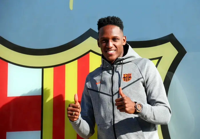 Colombian soccer player Yerry Mina poses in front of a FC Barcelona logo at their offices next to Camp Nou stadium in Barcelona, Spain January 12, 2018.