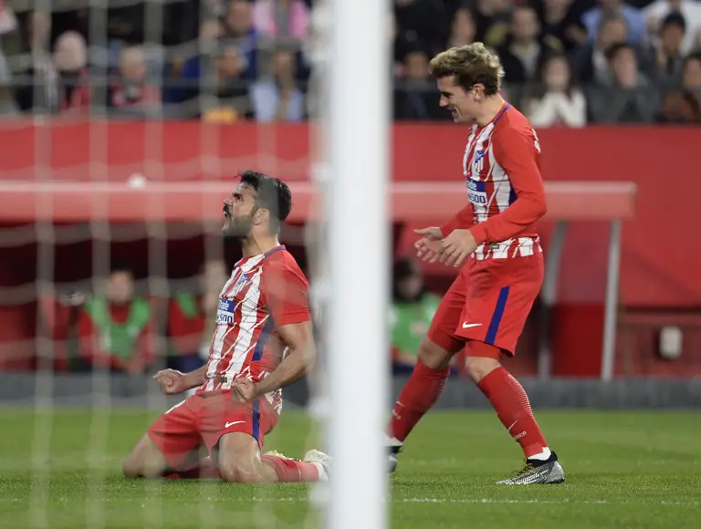 Atletico Madrid's Spanish forward Diego Costa (L) celebrates  with Atletico Madrid's French forward Antoine Griezmann (R) after scoring a goal during the Spanish league football match between Sevilla FC and Club Atletico de Madrid at the Ramon Sanchez Pizjuan stadium in Sevilla on February 25, 2018. / AFP PHOTO / Cristina Quicler