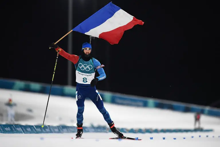 France's Martin Fourcade waves the French flag as he wins the men's 12,5km pursuit biathlon event during the Pyeongchang 2018 Winter Olympic Games in Pyeongchang on February 12, 2018. / AFP PHOTO / FRANCK FIFE