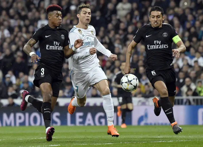 Real Madrid's Portuguese forward Cristiano Ronaldo (C) vies with Paris Saint-Germain's Brazilian defender Marquinhos (R) and Paris Saint-Germain's French defender Presnel Kimpembe during the UEFA Champions League round of sixteen first leg football match Real Madrid CF against Paris Saint-Germain (PSG) at the Santiago Bernabeu stadium in Madrid on February 14, 2018.   / AFP PHOTO / CHRISTOPHE SIMON