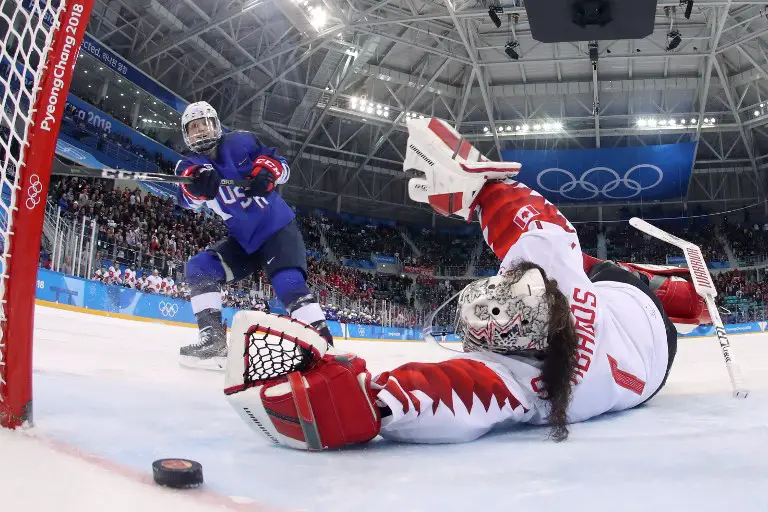 USA's Jocelyne Lamoureux-Davidson (L) scores on Canada's Shannon Szabados during the penalty-shot shootout in the women's gold medal ice hockey match between the US and Canada during the Pyeongchang 2018 Winter Olympic Games at the Gangneung Hockey Centre in Gangneung on February 22, 2018.   / AFP PHOTO / POOL / -