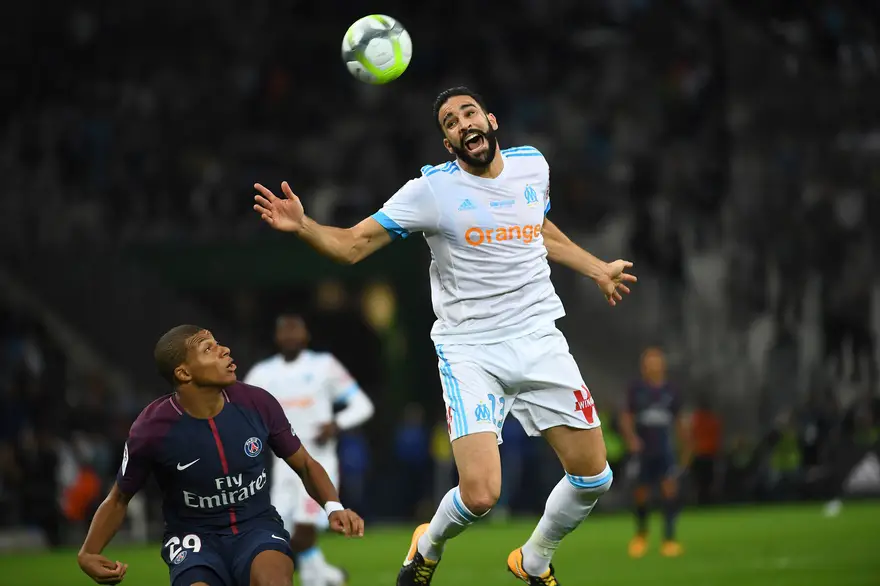 Paris Saint-Germain's French forward Kylian Mbappe (L) vies for the ball with Marseille's French defender Adil Rami  during the French L1 football match between Marseille (OM) and Paris Saint-Germain (PSG) on October 22, 2017, at the Velodrome Stadium in Marseille, southeastern France. / AFP PHOTO / ANNE-CHRISTINE POUJOULAT