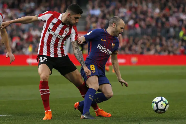Athletic Bilbao's Spanish defender Unai Nunez (l) vies with Barcelona's Spanish midfielder Andres Iniesta (R) during the Spanish League football match between FC Barcelona and Athletic Club Bilbao at the Camp Nou stadium in Barcelona on March 18, 2018. / AFP PHOTO / Pau Barrena