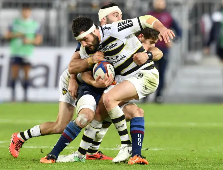 La Rochelle's French centre Pierre Aguillon (C) is tackled during the French Top 14 rugby union match between Bordeaux-Begles (UBB) and La Rochelle (SR) at The Matmut-Atlantique stadium in Bordeaux, southwestern France on December 23, 2017. / AFP PHOTO / NICOLAS TUCAT