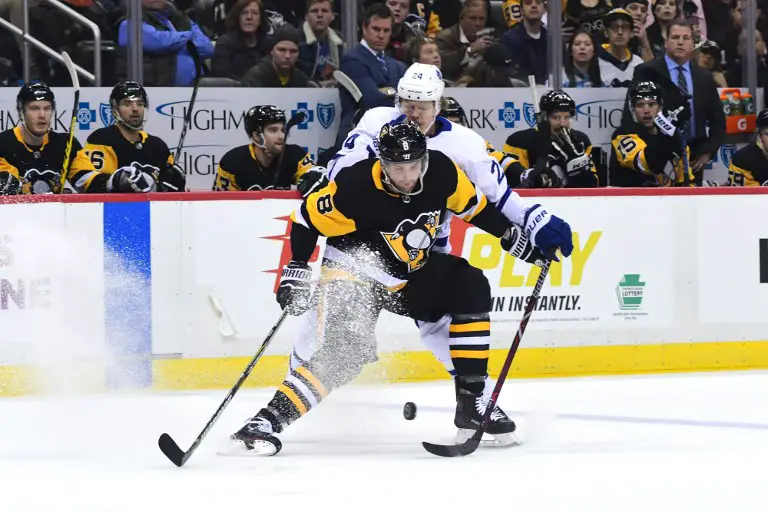 PITTSBURGH, PA - FEBRUARY 17: Brian Dumoulin #8 of the Pittsburgh Penguins fights for the puck against Kasperi Kapanen #24 of the Toronto Maple Leafs at PPG PAINTS Arena on February 17, 2018 in Pittsburgh, Pennsylvania.   Matt Kincaid/Getty Images/AFP