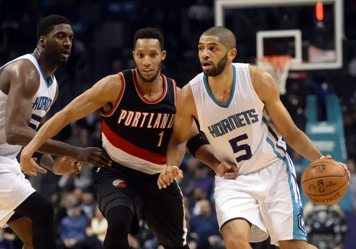 Jan 18, 2017; Charlotte, NC, USA; Charlotte Hornets guard forward Nicolas Batum (5) drives past Portland Trail Blazers guard forward Evan Turner (1) during the second half of the game at the Spectrum Center. Hornets win 107-85.