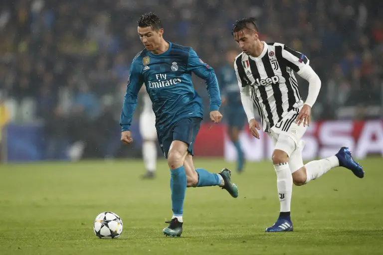 Real Madrid's Portuguese forward Cristiano Ronaldo (L) vies with Juventus' midfielder from Uruguay Rodrigo Bentancur during the UEFA Champions League quarter-final first leg football match between Juventus and Real Madrid at the Allianz Stadium in Turin on April 3, 2018. / AFP PHOTO / Isabella BONOTTO