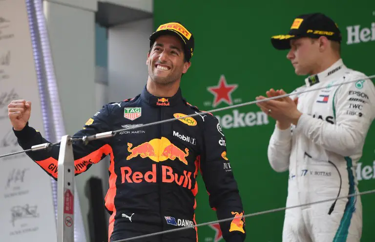Red Bull's Australian driver Daniel Ricciardo (L) celebrates his victory with second-placed Mercedes' Finnish driver Valtteri Bottas (R) on the podium after the Formula One Chinese Grand Prix in Shanghai on April 15, 2018. / AFP PHOTO / GREG BAKER