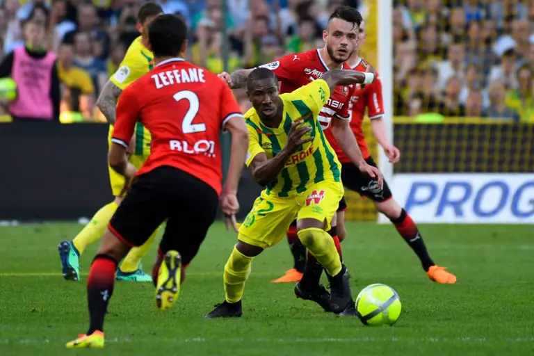 Nantes' Burkinabe forward Prejuce Nakoulma (C) vies with Rennes' French defender Jérémy Gellin (R) during the French L1 football match Nantes versus Rennes on April 20, 2018 at the La Beaujoire stadium in Nantes, western France.  / AFP PHOTO / DAMIEN MEYER