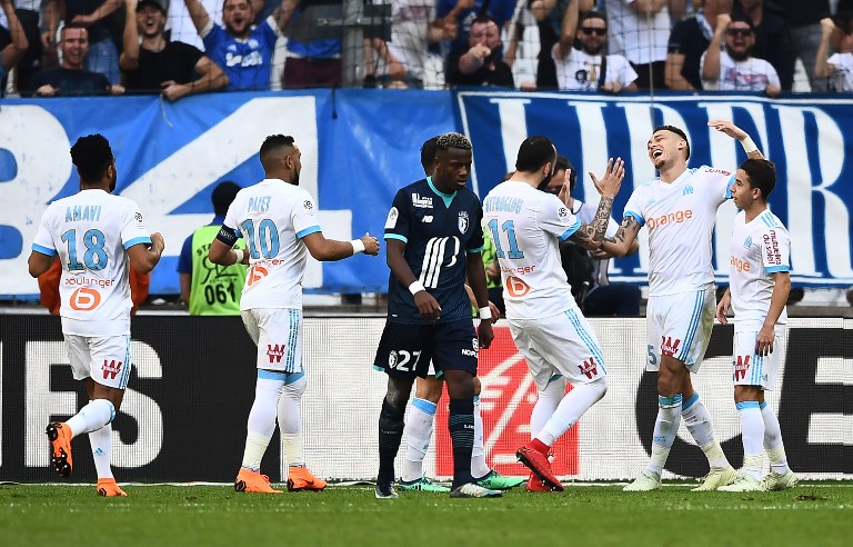 Marseille's Greek forward Konstantinos Mitroglou (3-L) celebrates with teammates after scoring a goal during the French L1 football match Marseille versus Lille on April 21, 2018 at the Velodrome stadium in Marseille, southern France. / AFP PHOTO / ANNE-CHRISTINE POUJOULAT