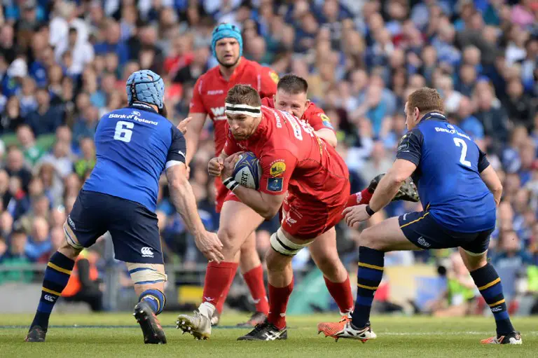 Scarlets' Lewis Rawlins (C) is tackled by Leinster's Australian flanker Scott Fardy (L) and Leinster's Irish hooker Sean Cronin during the European Champions Cup rugby union semi-final between Leinster and Scarlets at Aviva Stadium in Dublin, Ireland on April 21, 2018. / AFP PHOTO / Barry CRONIN