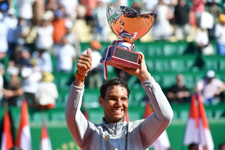 Spain's Rafael Nadal holds up the trophy as he celebrates his win over Japan's Kei Nishikori in their final match at the Monte-Carlo ATP Masters Series tournament on April 22, 2018, in Monaco. 
Nadal, 31-years-old, saw off Nishikori 6-3, 6-2 to become the first man to win a tournament 11 times in the Open era with his 76th ATP Tour triumph. Nadal's 31st Masters title is also an outright record, pulling him out of a tie with Novak Djokovic.
 / AFP PHOTO / YANN COATSALIOU