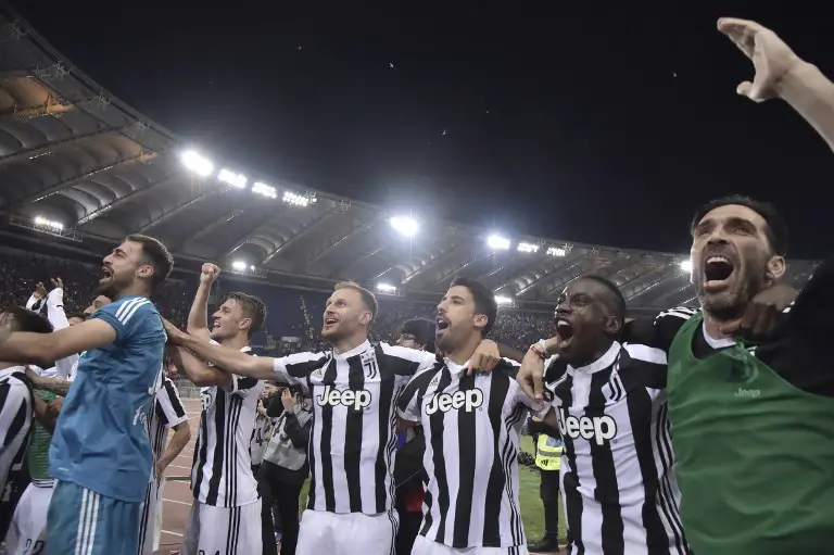 Juventus players celebrate at the end of the Italian Serie A football match AS Roma vs Juventus at the Olympic stadium on May 13, 2018 in Rome. Juventus won a seventh straight Serie A title on Sunday after a goalless draw against ten-man Roma at the Stadio Olimpico. 
The Turin giants become the first team to complete the league and Cup double for four consecutive seasons. It is the 34th Scudetto in Juventus's history.
 / AFP PHOTO / TIZIANA FABI