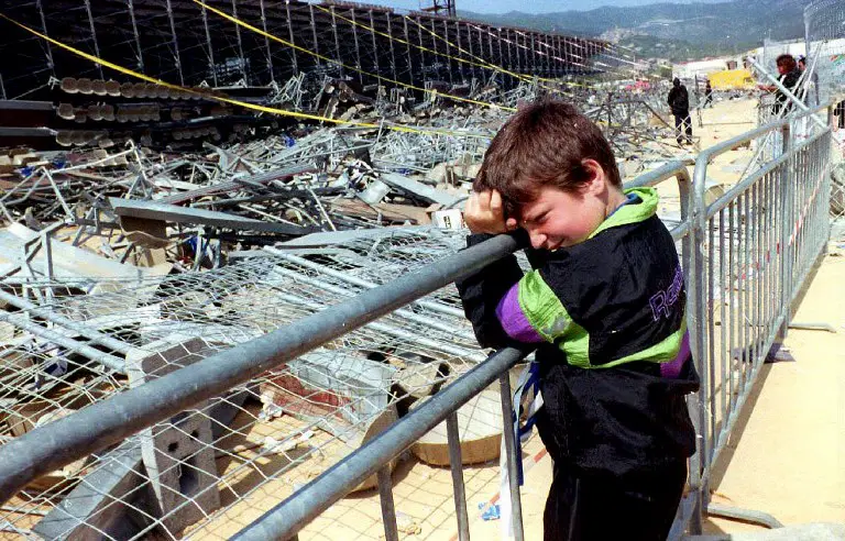 A boy leans on a fence 06 May 1992 in front of the temporary stand at Furiani stadium in Corsica that collapsed 05 May. Eighteen people were killed when the stand collapsed before a soccer match between Olympic de Marseille and Bastia. AFP PHOTO ANDRE DURAND / AFP PHOTO / ANDRE DURAND