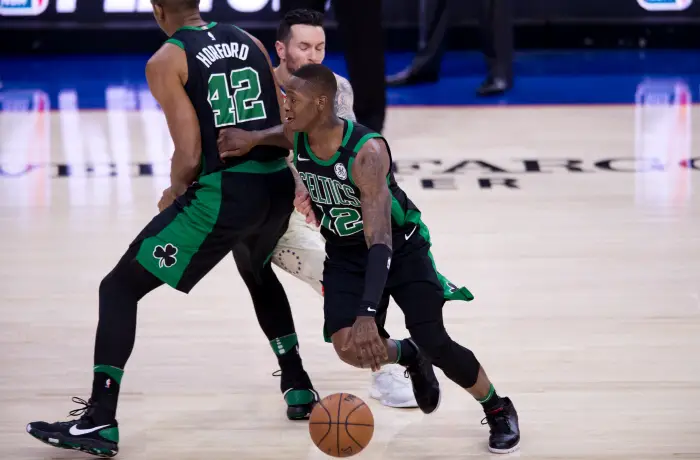 Boston Celtics Guard Terry Rozier III (12) carries the ball by Philadelphia 76ers Guard JJ Redick (17) on a pick from Boston Celtics Center Al Horford (42)