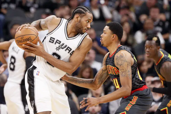 San Antonio Spurs small forward Kawhi Leonard (2) holds the ball while defended by Atlanta Hawks small forward Kent Bazemore (24)