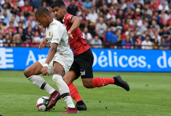 Paris Saint-Germain's French forward Kylian Mbappe (L) vies with Guingamp's French midfielder Ludovic Blas during the French L1 football match between Guingamp and Paris Saint-Germain, at the Roudourou stadium in Guingamp on August 18, 2018. / AFP PHOTO / FRED TANNEAU / DPPI