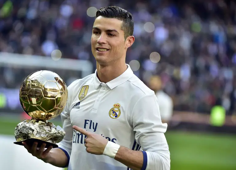 Real Madrid's Portuguese forward Cristiano Ronaldo poses with the Ballon d'Or France Football trophy before the Spanish league football match Real Madrid CF vs Granada FC at the Santiago Bernabeu stadium in Madrid on January 7, 2017. / AFP PHOTO / GERARD JULIEN