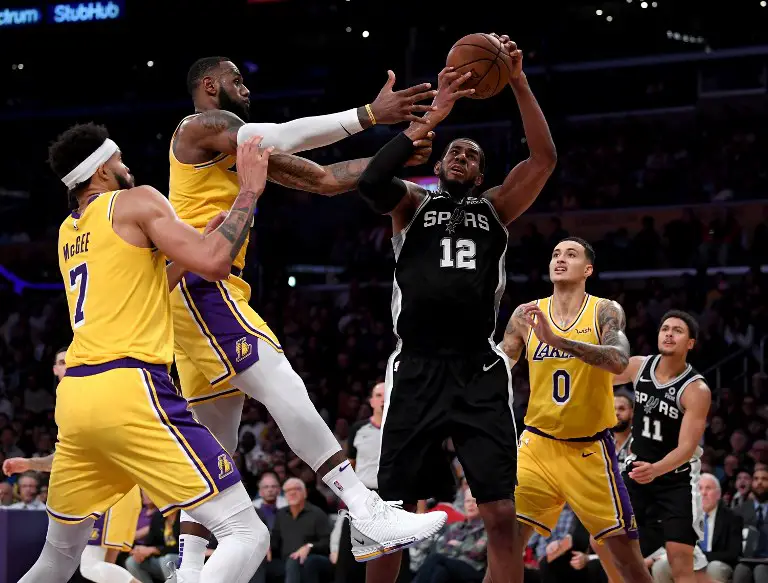 LOS ANGELES, CA - OCTOBER 22: LaMarcus Aldridge #12 of the San Antonio Spurs grabs a rebound from LeBron James #23 during a 143-142 Spurs overtime win at Staples Center on October 22, 2018 in Los Angeles, California.   Harry How/Getty Images/AFP