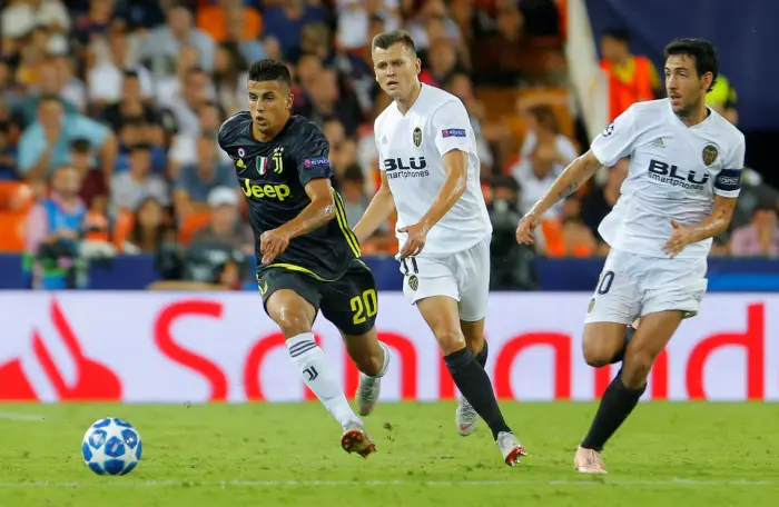 Juventus' Joao Cancelo in action with Valencia's Denis Cheryshev and Dani Parejo