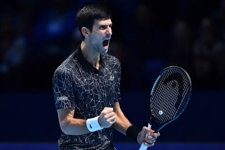 Serbia's Novak Djokovic reacts after breaking serve to go 4-3 in the second set against US player John Isner during their men's singles round-robin match on day two of the ATP World Tour Finals tennis tournament at the O2 Arena in London on November 12, 2018. (Photo by Glyn KIRK / AFP)