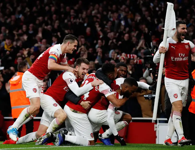 Arsenal's French striker Alexandre Lacazette celebrates with teammates after scoring their third goal during the English Premier League football match between Arsenal and Tottenham Hotspur at the Emirates Stadium in London on December 2, 2018. (Photo by Adrian DENNIS / AFP) / RESTRICTED TO EDITORIAL USE. No use with unauthorized audio, video, data, fixture lists, club/league logos or 'live' services. Online in-match use limited to 120 images. An additional 40 images may be used in extra time. No video emulation. Social media in-match use limited to 120 images. An additional 40 images may be used in extra time. No use in betting publications, games or single club/league/player publications. /