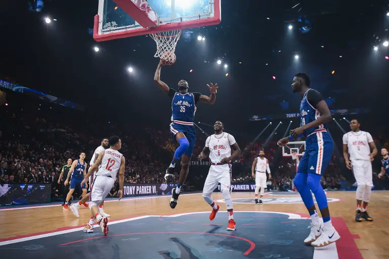 France's Alain Koffi (C) scores during the French All Star Game gala basketball match of the French Ligue Nationale de Basket (LNB) between French All Star team and Foreign All Star team at the AccorHotels Arena in Paris on December 29, 2018. - The LNB All Star Game is an exhibition match between a team of the best French players and a team of the best international players of the French Elite basketball league. (Photo by Lucas BARIOULET / AFP)