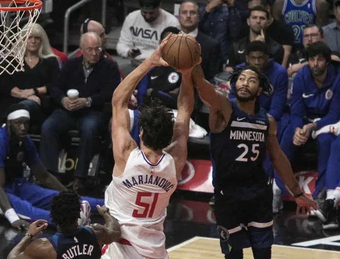 Boban Marjanovic #51 of the Los Angeles Clippers is blocked by Derrick Rose #25 of the Minnesota Timberwolves