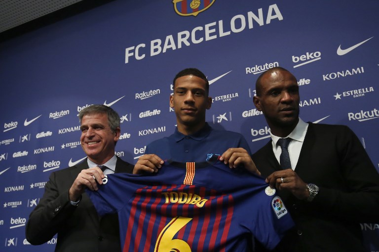 Barcelona´s new player French defender Jean-Clair Todibo (C) poses with Barcelona's French technical secretary Eric Abidal (R) and Barcelona's Spanish vice president Jordi Mestre (L) before giving a press conference during his presentation at the Camp Nou stadium in Barcelona on February 1, 2019. (Photo by Pau Barrena / AFP)