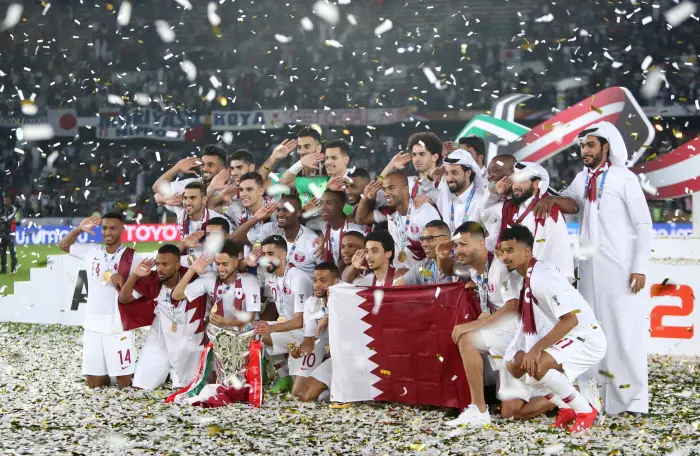 Qatar's Hasan Al Haydos and team mates pose with the trophy as they celebrate winning the Asian Cup
