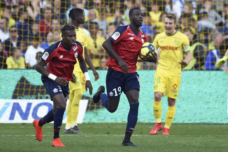 Lille's French Ivorian forward Nicolas Pepe (R) celebrates after scoring a penalty kick  during the French L1 football match between Nantes (FCN) and Lille (LOSC) at the La Beaujoire Stadium in Nantes, western France, March 31, 2019. (Photo by Sebastien SALOM-GOMIS / AFP)