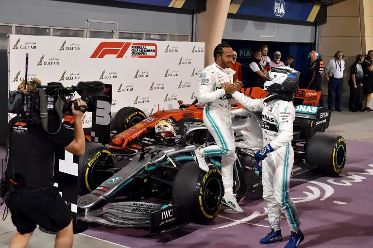 Mercedes' British driver Lewis Hamilton celebrates with his teammate Mercedes' Finnish driver Valtteri Bottas (second) after winning the Formula One Bahrain Grand Prix at the Sakhir circuit in the desert south of the Bahraini capital Manama, on March 31, 2019. (Photo by Andrej ISAKOVIC / AFP)