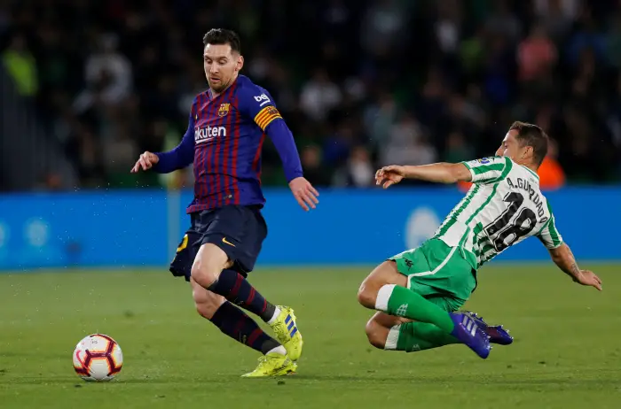 Barcelona's Lionel Messi in action with Real Betis' Andres Guardado