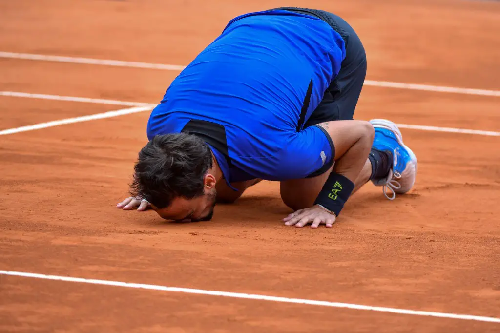 Italy's Fabio Fognini kisses the court as he celebrates after winning against Serbia's Dusan Lajovic at the end of the final tennis match of the Monte-Carlo ATP Masters Series tournament in Monaco on April 21, 2019. (Photo by Yann COATSALIOU / AFP)